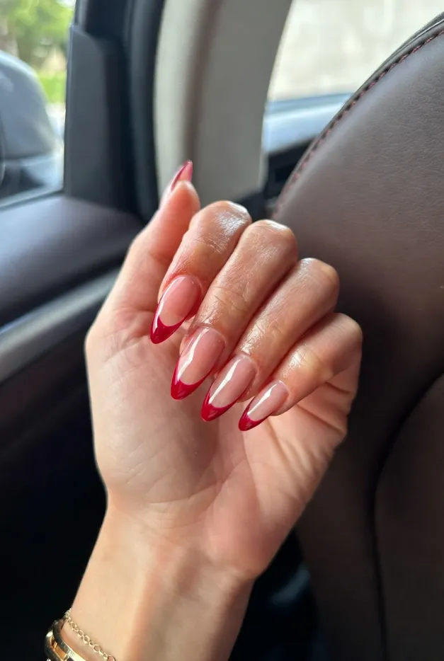 Glossy red French tip nails with a nude base and almond shape for classy summer French tip nails 2026.