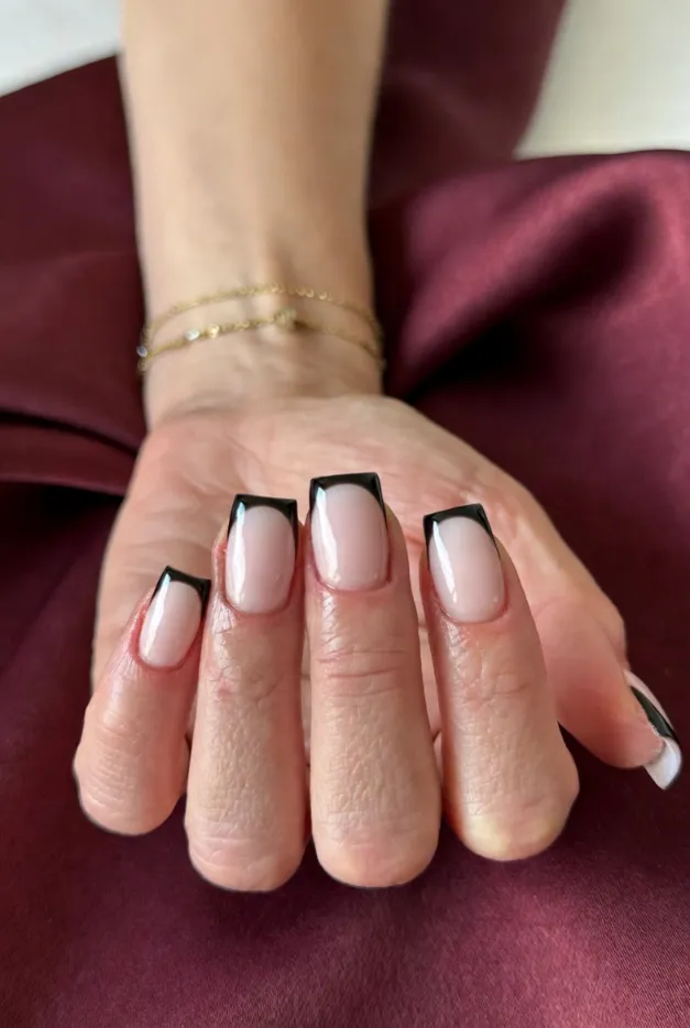 Black micro French tip nails on short glossy pink nails for a modern simple summer manicure.