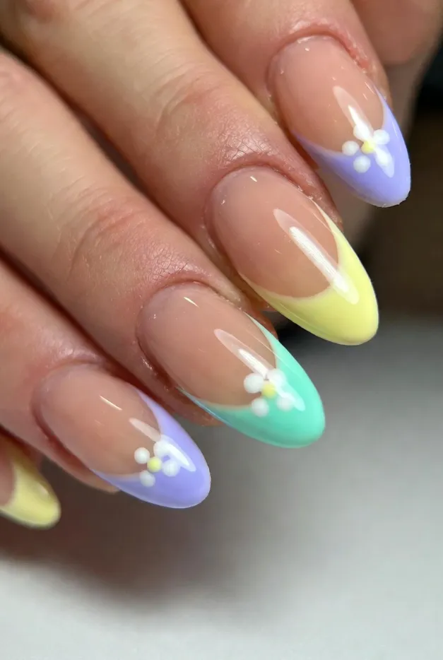 Pastel floral French tip nails with almond shape and glossy nude base for a soft summer nail design.