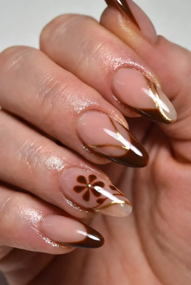 Chocolate brown French tip nails with gold accents and almond shape for an elegant summer nail look.