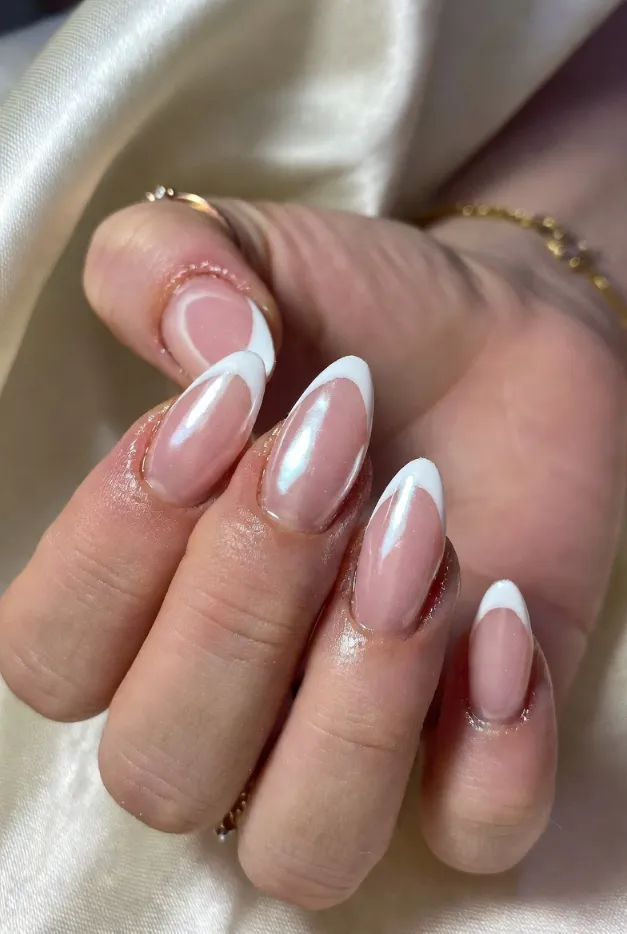 Pearl white French tip nails with milky pink base and almond shape for an elegant summer manicure.