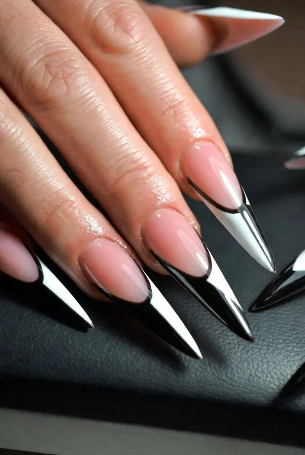 Geometric black and white French tip nails with stiletto shape for a bold summer nail design in 2026.