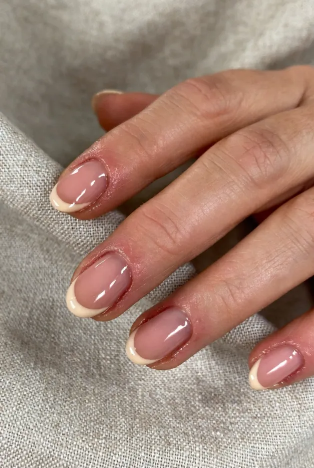 Soft nude French tip nails with a glossy natural base for a minimalist summer manicure idea.