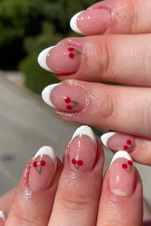 Cherry accent French tip nails with white tips and glossy pink base for cute summer French nails 2026.