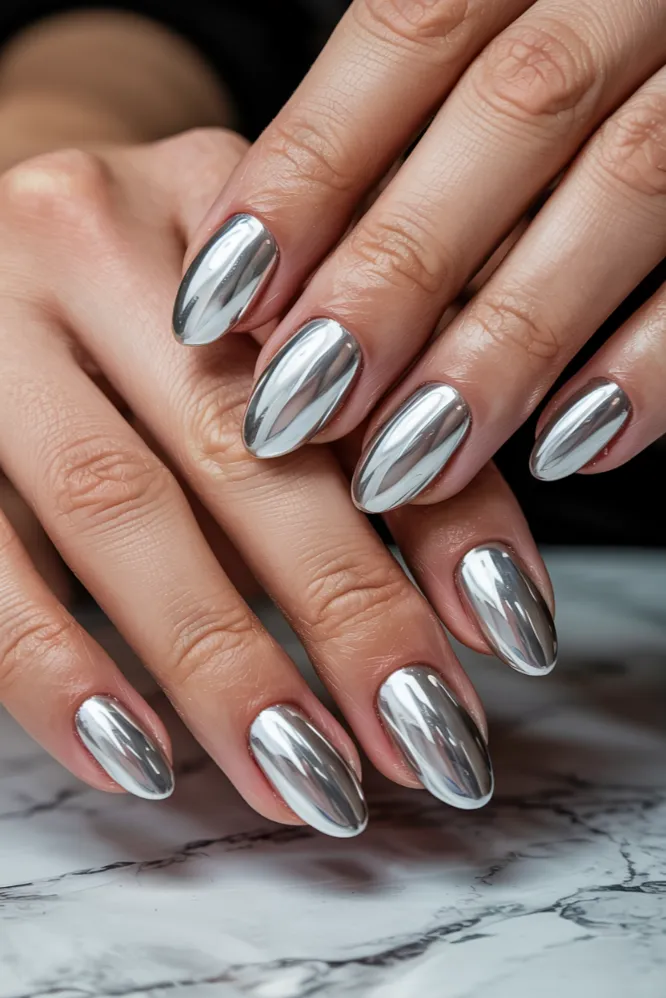 Liquid silver chrome nail ideas on almond-shaped nails with mirror finish and icy white base