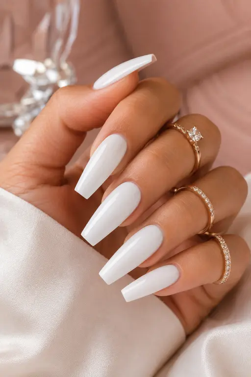 Long white acrylic coffin nails with a glossy and glamorous salon finish.
