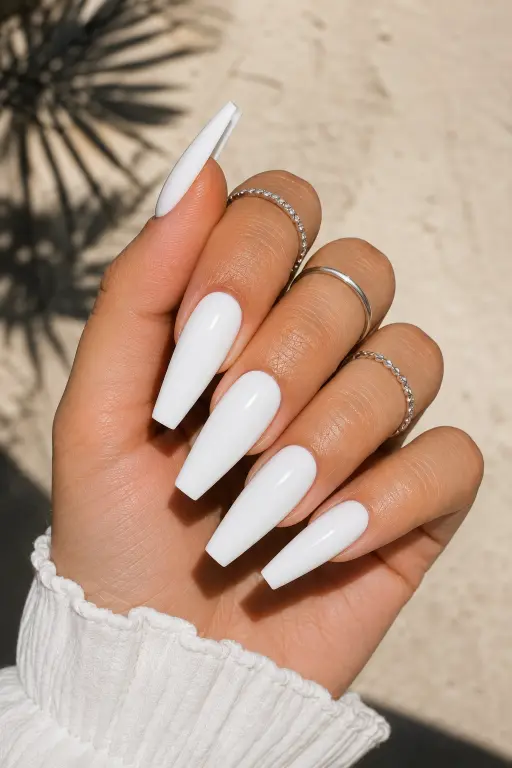 Long white coffin nails with a sleek glossy finish for a bold modern manicure.